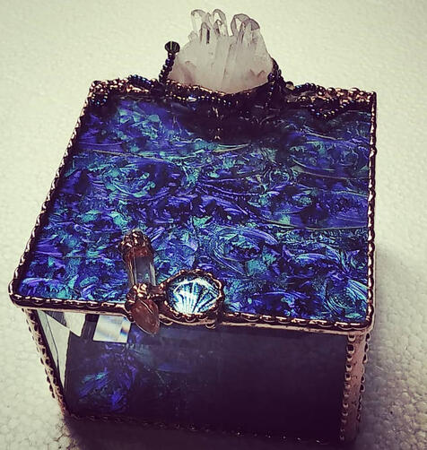close up of blue and purple stained-glass box with natural crystal accents